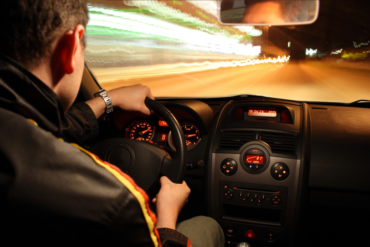 The photo shows a man driving a sports car